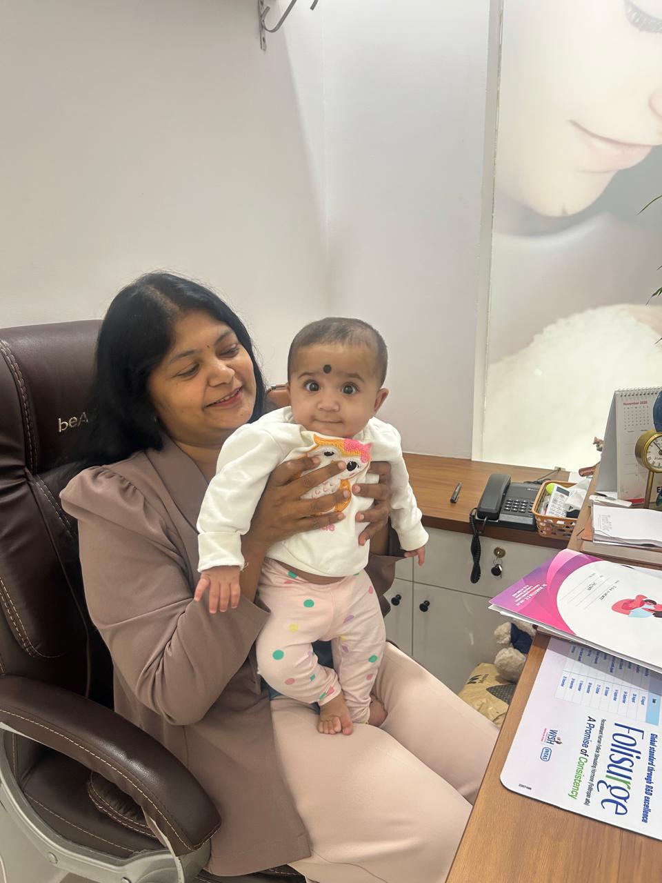 Dr. Mamtha C.V. with a baby during a clinic visit
